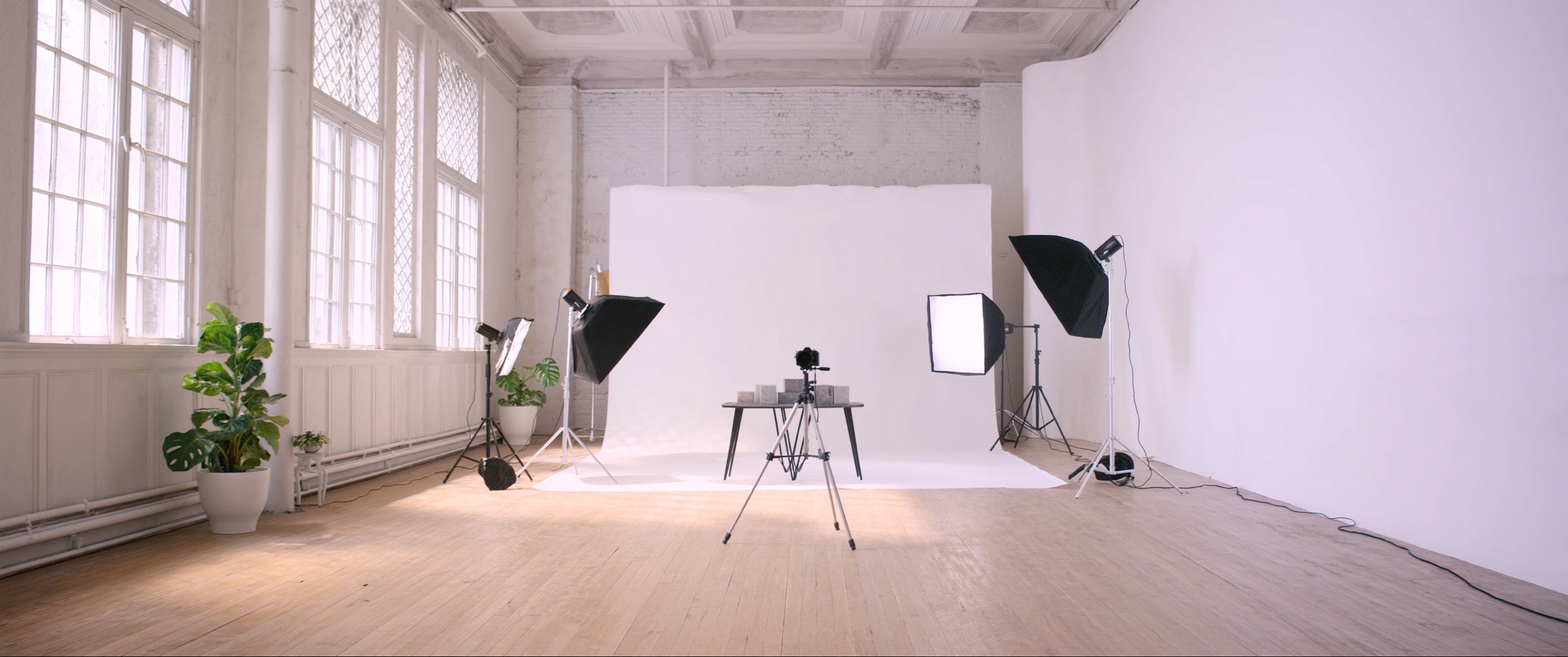 A daylit production studio with a camera, lighting and a product table